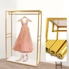 a display case with a pink dress and gold suitcases on the floor next to it