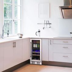 a wine cooler in the middle of a kitchen