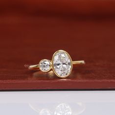 two diamond rings sitting on top of a wooden surface