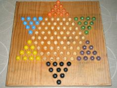 a wooden board game with many different colored balls