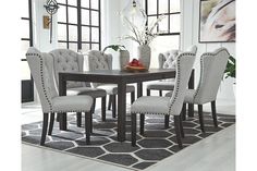 a dining room table with chairs and a rug