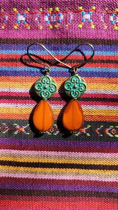 Bright orange earrings with Czech glass teardrops accented by gorgeous turquoise Patina metal beads.. Antique brass accent beads.  The one-of-a-kind earrings are 2 inches in length, including the antique brass ear wire hooks.  Lightweight. Unique. Handmade.  One of a kind design. Smoke free artist's studio. Bohemian Orange Teardrop Jewelry, Bohemian Turquoise Teardrop Drop Earrings, Turquoise Bohemian Teardrop Earrings, Brown Czech Glass Teardrop Earrings, Orange Bohemian Drop Earrings Jewelry, Orange Bohemian Drop Earrings, Bohemian Orange Jewelry Nickel Free, Bohemian Orange Nickel-free Jewelry, Bohemian Teardrop Amber Jewelry