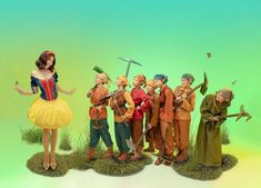 a group of figurines standing on top of a grass covered field next to each other