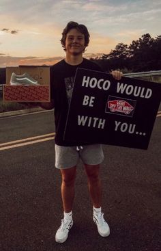 a man holding up a sign that says hoco would be with you