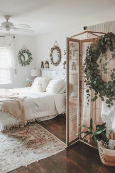 a bedroom with a bed, mirror and plants