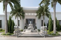 a large white building with palm trees and fountains