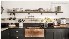 an image of a kitchen with black cabinets and white walls in the background, including open shelving