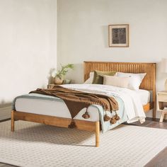 a bed sitting on top of a white rug next to a wooden headboard and foot board