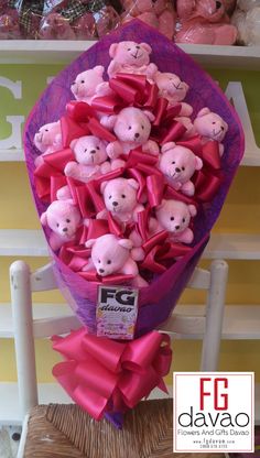 a bunch of pink teddy bears sitting in a purple bow on top of a chair