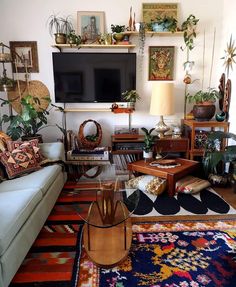 a living room filled with lots of furniture and plants on top of it's shelves