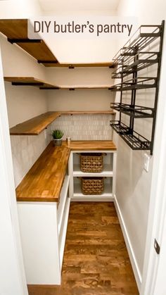 an empty walk in pantry with shelves and baskets on the counter top, next to a wooden floor