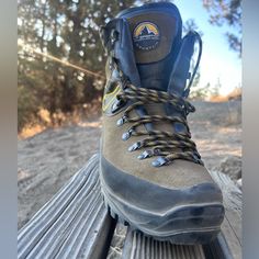 a pair of hiking boots sitting on top of a wooden bench