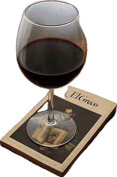 a glass of wine sitting on top of a book