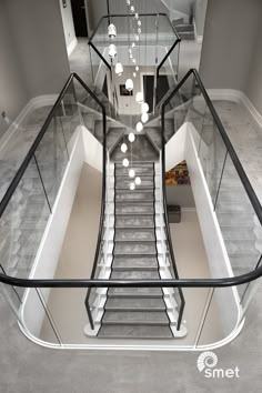 a staircase with glass railings leading up to the second floor