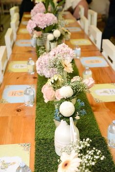 a long table with flowers and vases on it