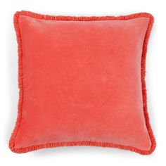 an orange pillow with fringe trim on the front and back of it, against a white background