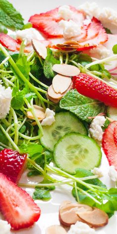 a salad with strawberries, cucumbers and almonds