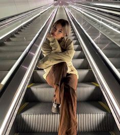 a woman sitting on top of an escalator