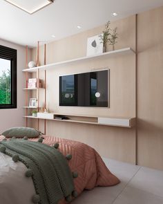 a bedroom with a large flat screen tv mounted on the wall above it's bed