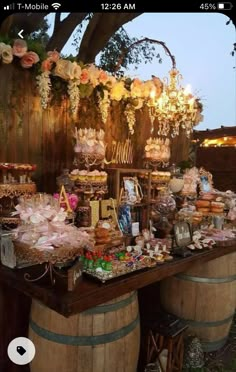 an outdoor dessert table with wine barrels