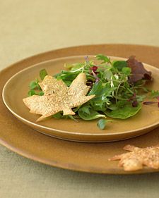 a plate that has some food on it with crackers next to it and a glass of wine in the background