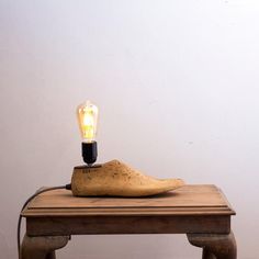 a banana sitting on top of a wooden table with a light bulb in the shape of a shoe