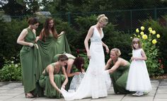 a group of women standing around each other in dresses