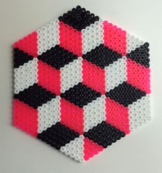 a piece of art made out of legos on a white surface with pink and black squares