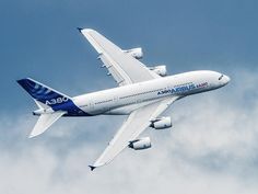 an airplane is flying in the sky on a clear day with some clouds behind it