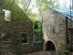 an old stone building in the woods