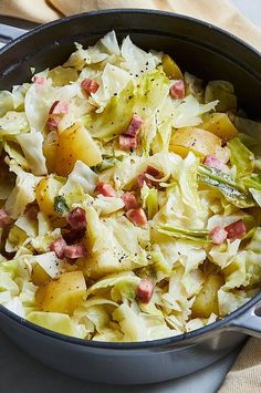 a pot filled with cabbage and potatoes on top of a table