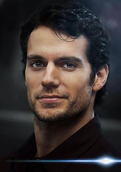 a man with curly hair and blue eyes looks at the camera while wearing a black shirt