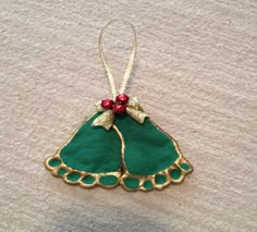 a green christmas ornament hanging from a string on top of a white table