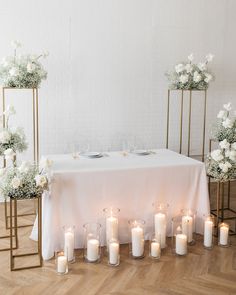 a table with white flowers and candles on it