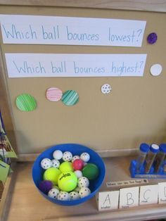 a blue bowl filled with balls next to a sign that says which ball bones lowest?