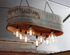 an old bucket is hanging from the ceiling with light bulbs in it and some lights are on