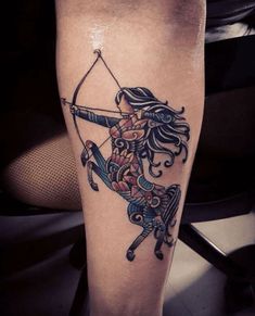 a woman with a bow and arrow tattoo on her leg