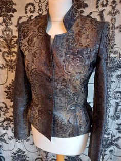 Fabulous jacquard satin jacket.Polyester + cotton. Edwardian steampunk vibe Quality look and feels lightweight Two tone black over bronze with gothic rose overlay Fully lined in black satin Nehru  stand up collar. Military button epaulette shoulders with padding for that glam 80s new romantic look Fitted with peplum 50s style hem fill. panelled. Sz UK 8 US 4 Bust 32" Waist 28" Hips 34" length 21" Sleeve 24.5" Gothic witches ~ Whitby steampunk ~ Coplay 80s pop icon ~ Cosplay Military display ~ Gi Fall Party Brocade Outerwear, Formal Brocade Outerwear For Fall, Fitted Steampunk Party Outerwear, Fitted Brocade Outerwear For Fall, Steampunk Long Sleeve Formal Outerwear, Elegant Spring Outerwear For Costume Party, Fall Brocade Long Sleeve Outerwear, Fall Long Sleeve Brocade Outerwear, Elegant Fall Blazer For Costume Party