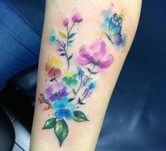 a colorful flower tattoo on the arm