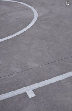 a man riding a skateboard down the middle of a parking lot next to an arrow