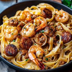 a bowl filled with pasta and shrimp on top of a table