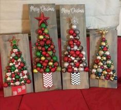 three wooden christmas trees with ornaments on them