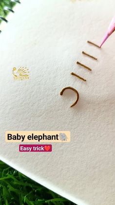 a baby elephant sticker on the back of a book with a pink pen sticking out of it