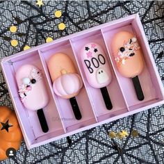 the three items in the box are decorated with flowers and boo eyes on them, along with pumpkins