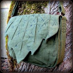 a green bag hanging on the side of a tree