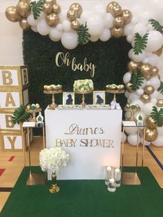 a baby shower is set up with gold and white balloons