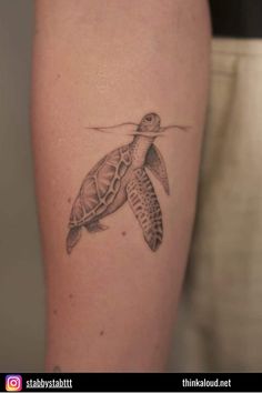 a small turtle tattoo on the arm