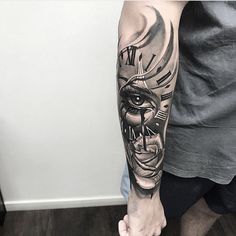 a man's arm with a clock and face tattoo on the left side of his arm