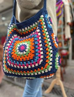 a woman carrying a crocheted handbag on her shoulder