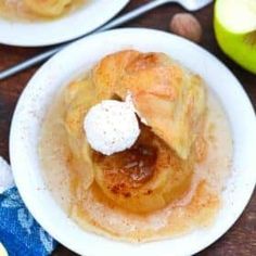 two white plates topped with food next to an apple